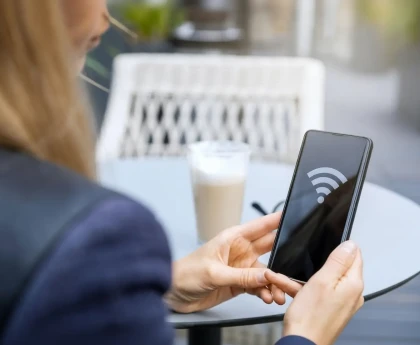 Smartphone connecté à un Wi-Fi public avec symbole de danger